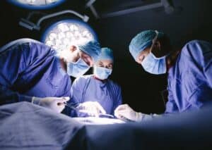 A team of surgeons focused on a patient during surgery in a well-equipped operating room.