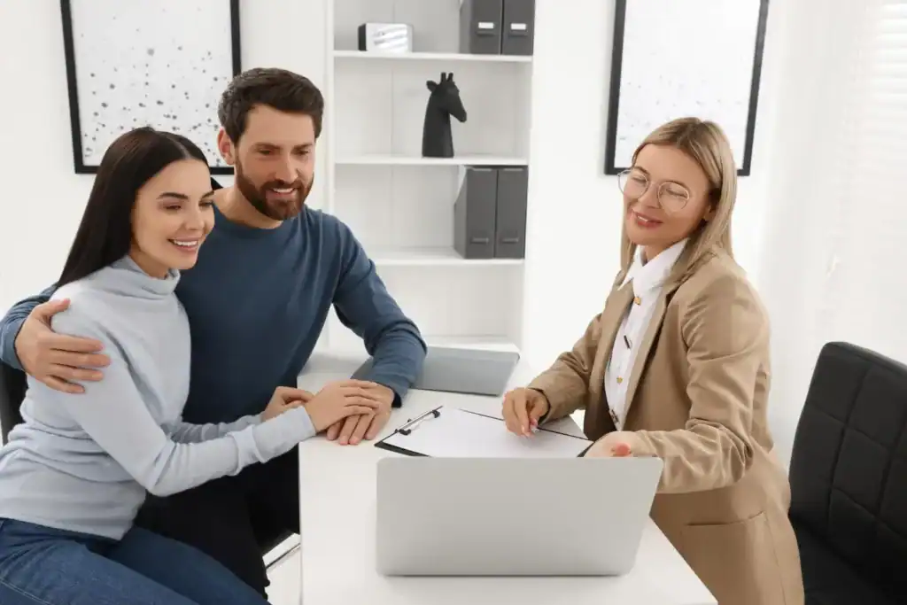 Insurance advisor explaining international health insurance options to a couple in a professional office setting